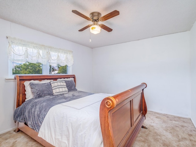 carpeted bedroom with a textured ceiling and ceiling fan