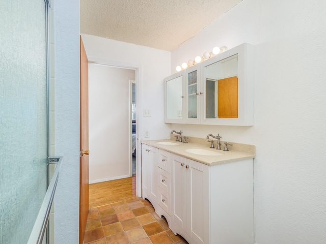 bathroom with a textured ceiling and vanity