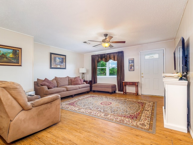 living room with wood-type flooring, a textured ceiling, and ceiling fan