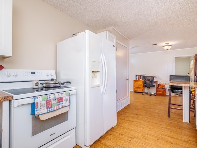 kitchen with white cabinets, white appliances, light hardwood / wood-style flooring, and a textured ceiling