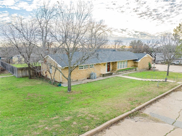 view of front of home with central AC and a front yard