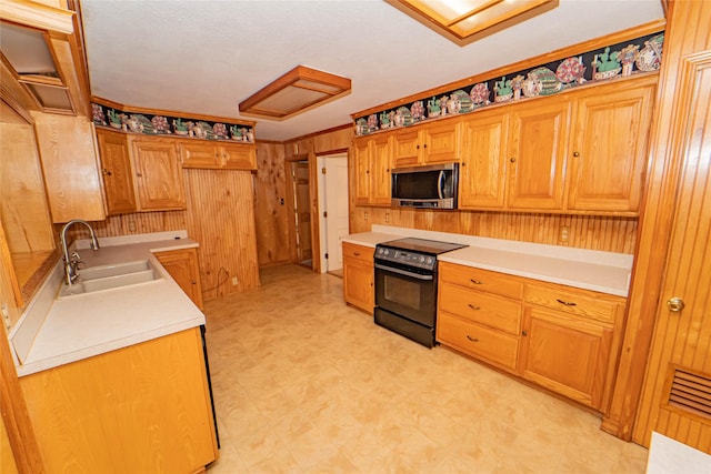 kitchen with sink, electric range, and wood walls