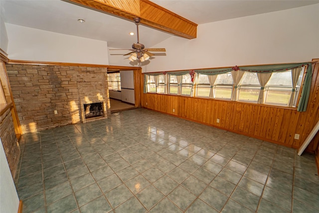 unfurnished living room with a fireplace, wooden walls, lofted ceiling with beams, ceiling fan, and tile patterned floors