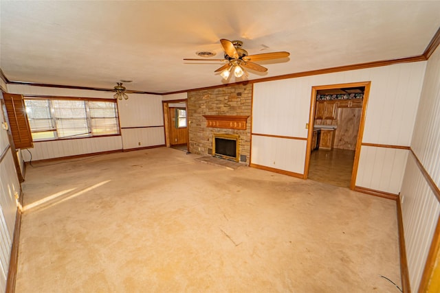 unfurnished living room featuring crown molding, light carpet, a fireplace, and ceiling fan