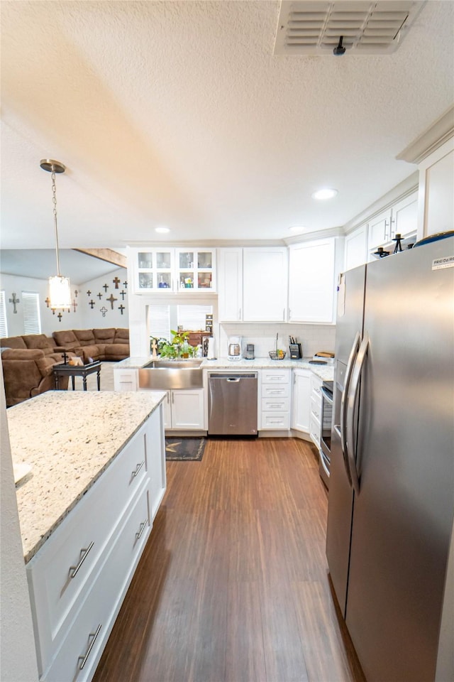 kitchen featuring sink, appliances with stainless steel finishes, hanging light fixtures, dark hardwood / wood-style floors, and white cabinets