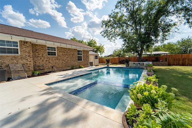 view of swimming pool featuring a storage shed and a lawn