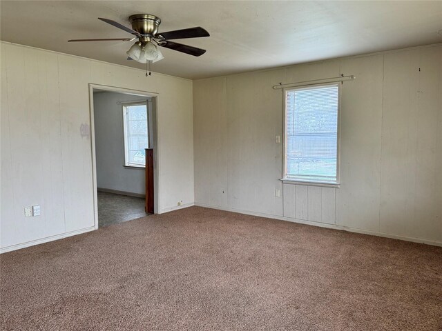 spare room featuring ceiling fan, a healthy amount of sunlight, and carpet