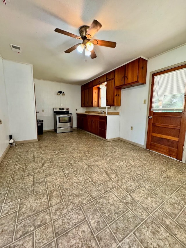 kitchen featuring ceiling fan, stainless steel electric range oven, and sink