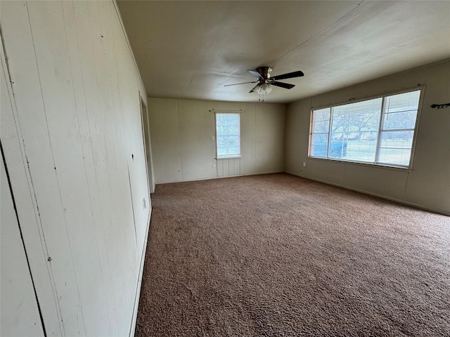 carpeted spare room featuring ceiling fan