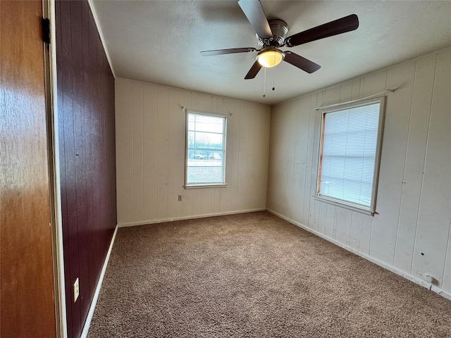 carpeted spare room with ceiling fan