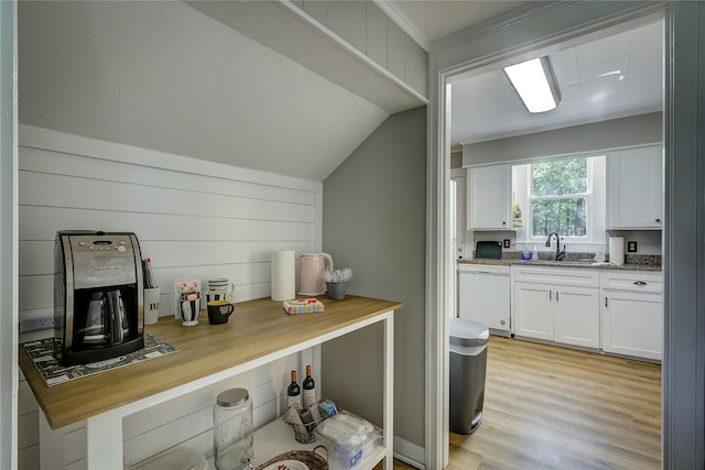 kitchen with lofted ceiling, sink, white cabinetry, light hardwood / wood-style flooring, and dishwasher