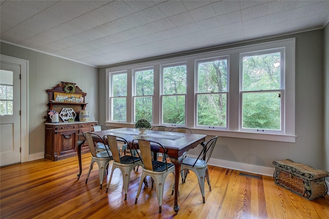 dining room featuring crown molding and light hardwood / wood-style floors