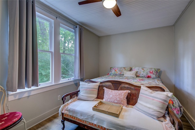 bedroom featuring multiple windows, wood-type flooring, and ceiling fan