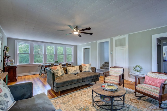 living room featuring crown molding, ceiling fan, and light hardwood / wood-style floors