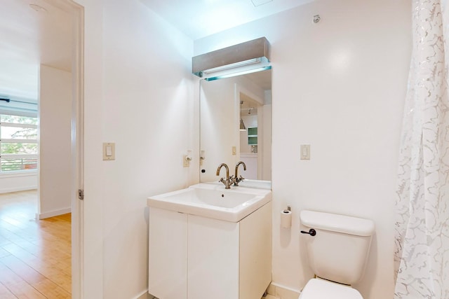 bathroom featuring vanity, toilet, and hardwood / wood-style floors