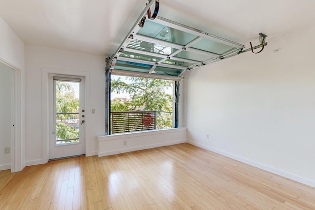 unfurnished room with a wealth of natural light and light hardwood / wood-style flooring