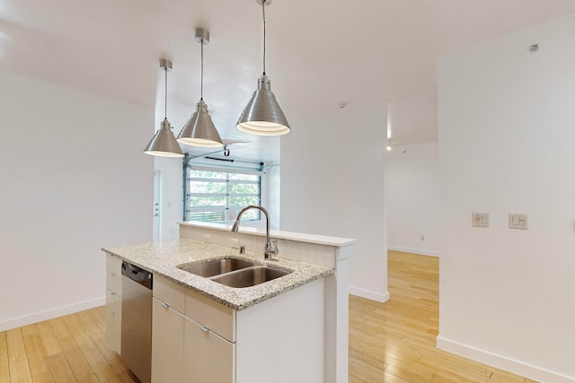 kitchen featuring pendant lighting, light hardwood / wood-style flooring, dishwasher, a kitchen island with sink, and sink