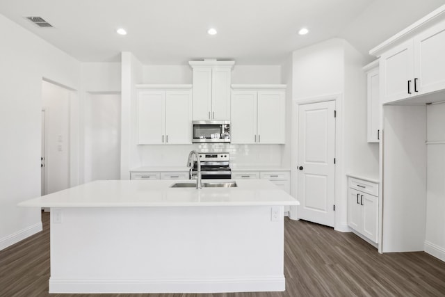 kitchen featuring a kitchen island with sink, dark hardwood / wood-style flooring, stainless steel appliances, and white cabinets