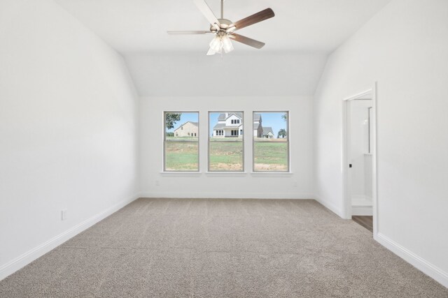 unfurnished room with vaulted ceiling, ceiling fan, and light colored carpet