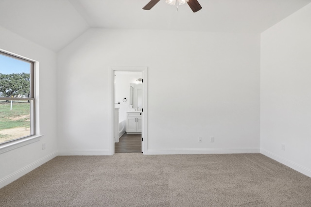 unfurnished bedroom featuring ceiling fan, lofted ceiling, connected bathroom, and carpet flooring