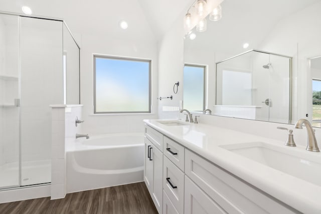 bathroom with shower with separate bathtub, hardwood / wood-style floors, vaulted ceiling, and vanity