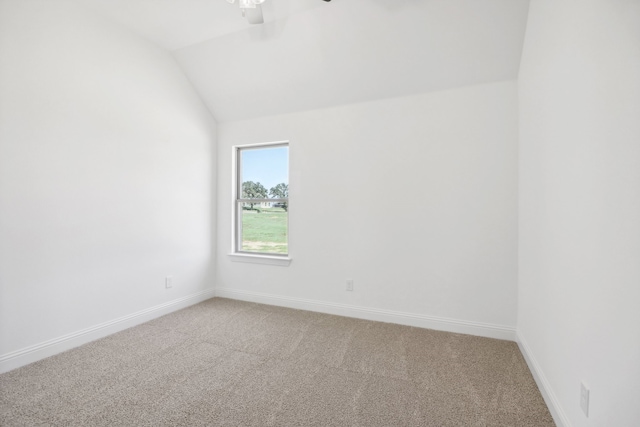 carpeted spare room featuring lofted ceiling