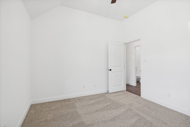 carpeted spare room with vaulted ceiling and ceiling fan