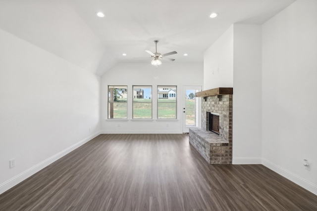 unfurnished living room with a brick fireplace, vaulted ceiling, ceiling fan, and dark hardwood / wood-style floors