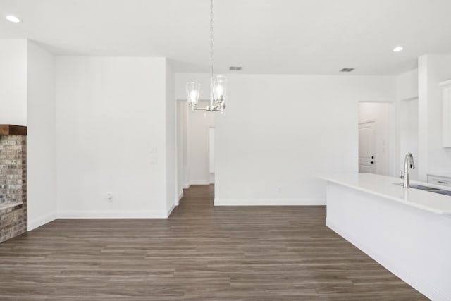 interior space featuring a chandelier, dark wood-type flooring, and sink