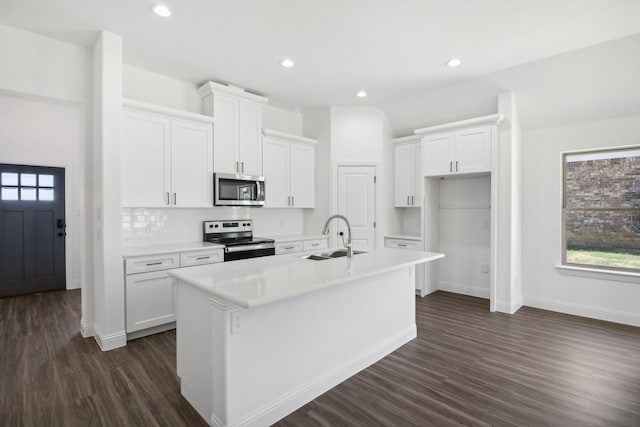 kitchen featuring a kitchen island with sink, appliances with stainless steel finishes, sink, and white cabinetry