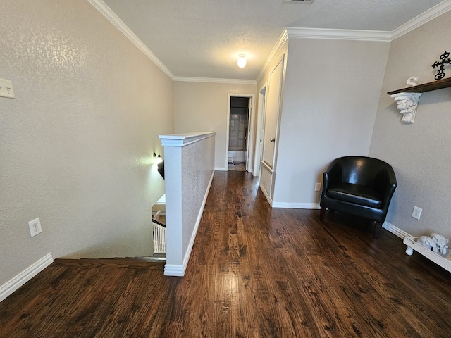 hallway with ornamental molding, wood finished floors, an upstairs landing, and baseboards