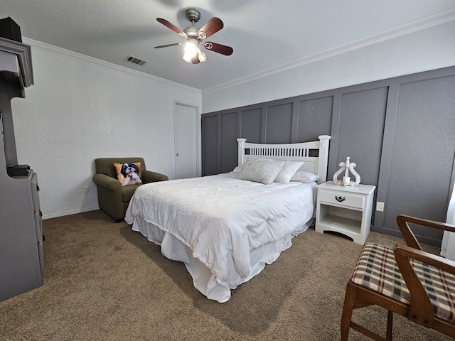 bedroom with visible vents, ceiling fan, ornamental molding, carpet, and a decorative wall