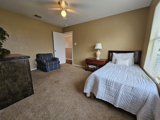 carpeted bedroom with baseboards, visible vents, and a ceiling fan