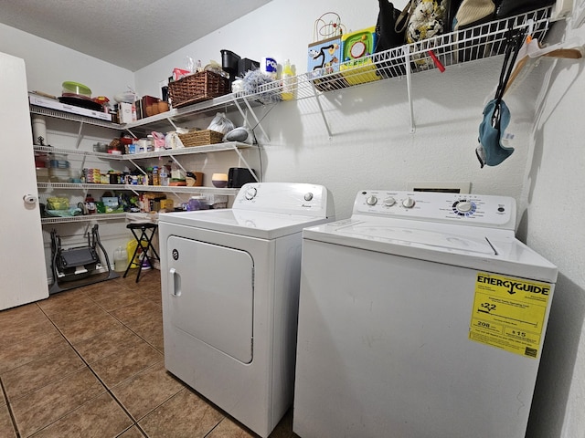 clothes washing area featuring a textured ceiling, laundry area, tile patterned flooring, and washer and dryer