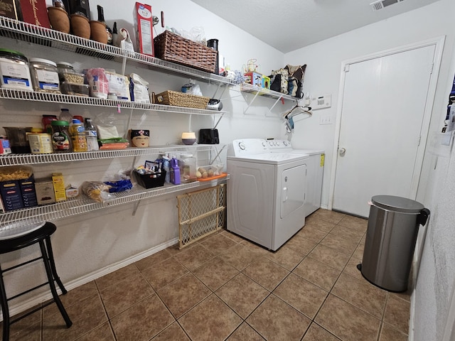 washroom with visible vents, separate washer and dryer, laundry area, baseboards, and tile patterned floors