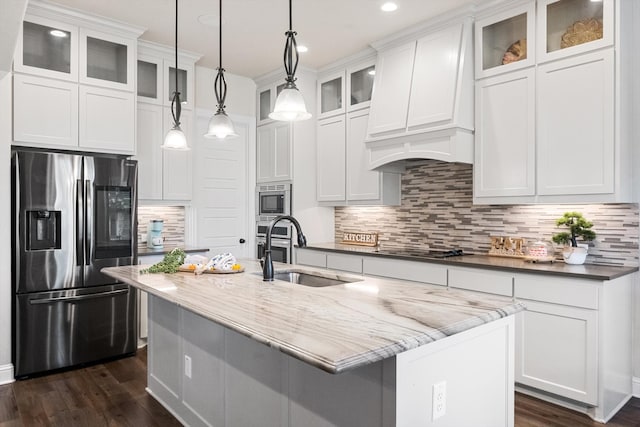 kitchen featuring sink, hanging light fixtures, dark stone countertops, appliances with stainless steel finishes, and white cabinetry