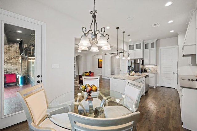 dining room with dark hardwood / wood-style flooring, a chandelier, and sink