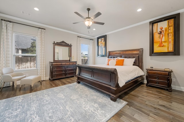 bedroom with dark hardwood / wood-style floors, ceiling fan, crown molding, and multiple windows