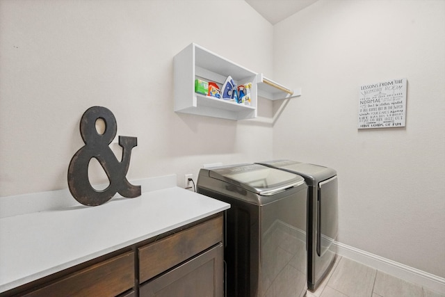 clothes washing area with light tile patterned floors and washer and clothes dryer