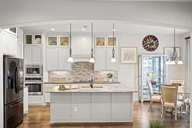 kitchen featuring an inviting chandelier, a center island with sink, hanging light fixtures, appliances with stainless steel finishes, and dark hardwood / wood-style flooring