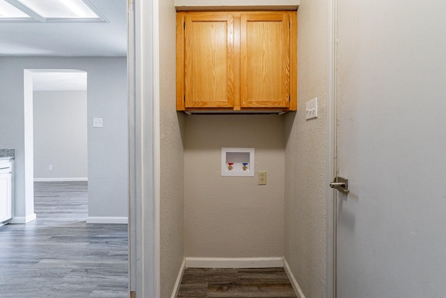 laundry room with hookup for a washing machine, cabinets, and hardwood / wood-style flooring