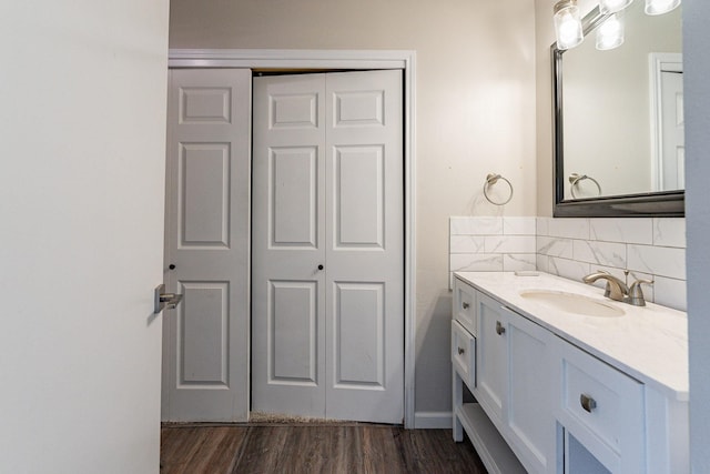 bathroom featuring hardwood / wood-style floors, decorative backsplash, and vanity