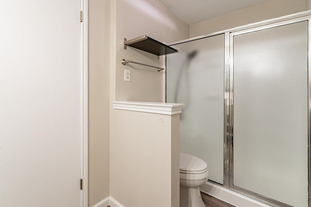 bathroom with a shower with shower door, wood-type flooring, and toilet