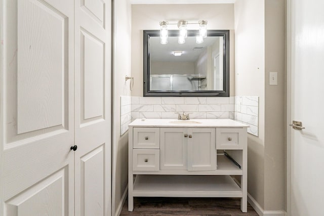 bathroom with vanity, backsplash, walk in shower, and hardwood / wood-style floors