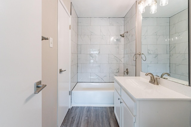 bathroom featuring hardwood / wood-style floors, tiled shower / bath, and vanity