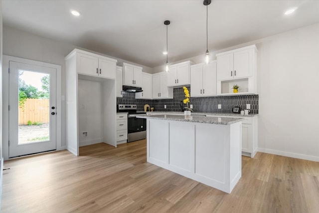 kitchen with decorative backsplash, electric range, light stone counters, and light wood-type flooring