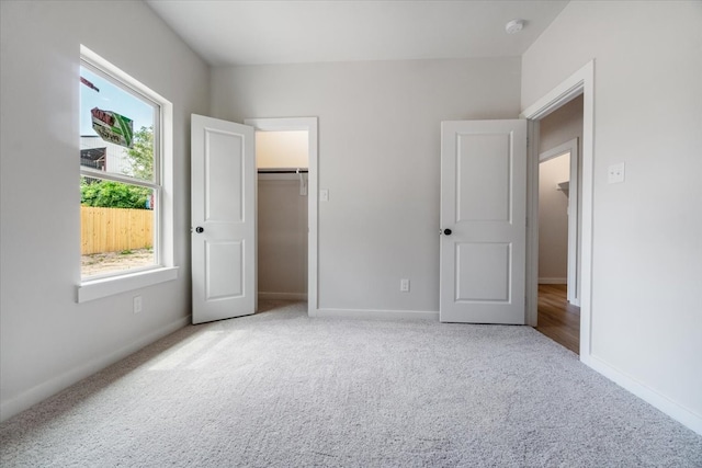 unfurnished bedroom with light carpet and a closet