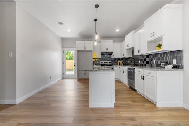 kitchen featuring white cabinetry, backsplash, light wood-type flooring, and stainless steel appliances