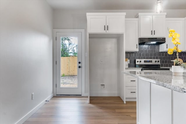 kitchen featuring white cabinetry, range, light stone counters, light hardwood / wood-style floors, and backsplash