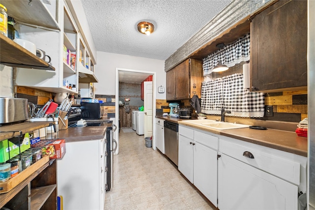 kitchen featuring washing machine and dryer, sink, appliances with stainless steel finishes, a textured ceiling, and white cabinets